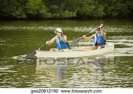 Two mid adult men boating in a lake View Large Photo Image Stock Image - Two mid adult men boating in a lake. Fotosearch