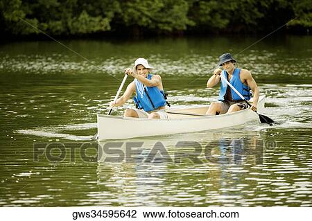 Stock Image - Two mid adult men boating in a lake. Fotosearch