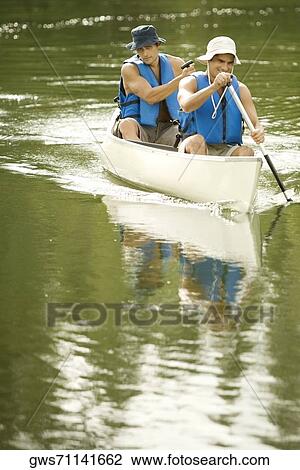 Two mid adult men boating in a lake View Large Photo Image Stock Image - Two mid adult men boating in a lake. Fotosearch