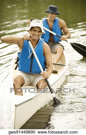 Two mid adult men boating in a river View Large Photo Image Stock Image - Two mid adult men boating in a river. Fotosearch