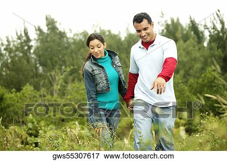 Stock Photo - Young couple walking in a field. Fotosearch