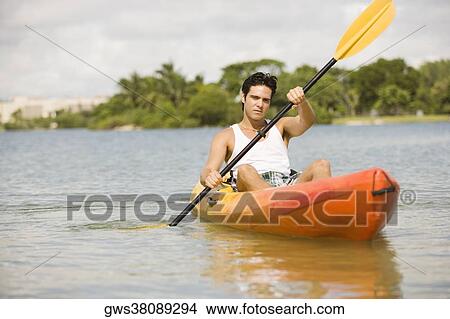 Picture - Young man kayaking in a lake. Fotosearch