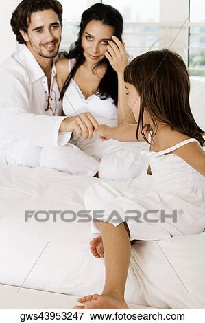 Stock Photo - Young man sitting on the bed with a young woman. Fotosearch