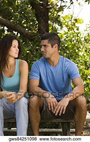 Stock Photo - Young woman and a mid adult man looking at each other. Fotosearch