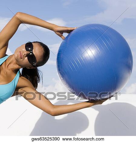 Young woman exercising with a fitness ball View Large Photo Image Stock Image - Young woman exercising with a fitness ball. Fotosearch