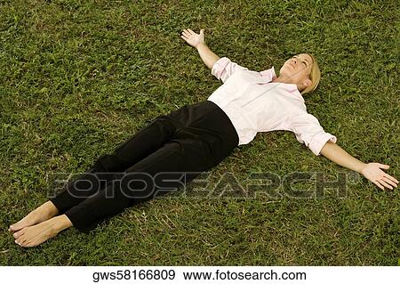 Young woman lying on the grass View Large Photo Image Stock Photo - Young woman lying on the grass. Fotosearch