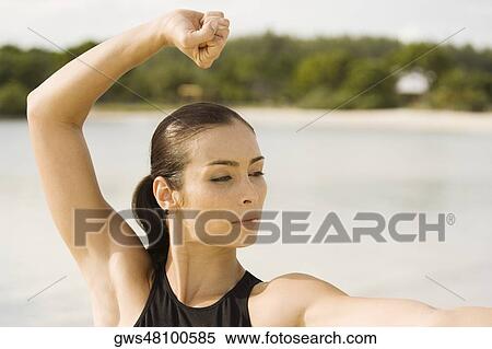 Stock Photography - Young woman practicing martial arts on the beach. Fotosearch