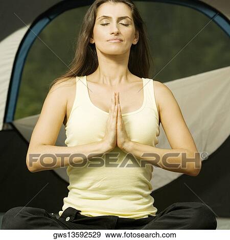 Young woman sitting in a prayer position View Large Photo Image Stock Photo - Young woman sitting in a prayer position. Fotosearch