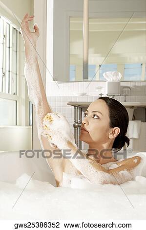 Young woman using a bath sponge on her arm View Large Photo Image Stock Image - Young woman using a bath sponge on her arm. Fotosearch