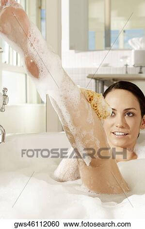 Young woman using a bath sponge on her leg View Large Photo Image Stock Image - Young woman using a bath sponge on her leg. Fotosearch