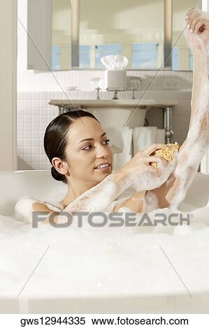 Young woman using a bath sponge on her arm View Large Photo Image Stock Photography - Young woman using a bath sponge on her arm. Fotosearch