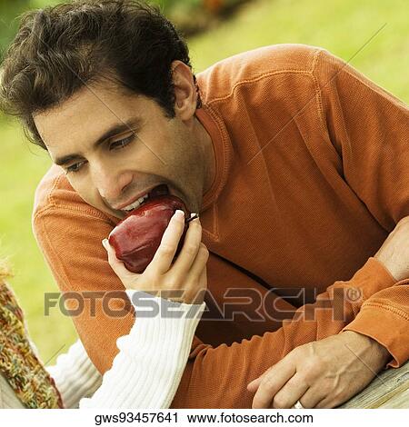 Young woman's hand feeding a mid adult man an apple View Large Photo Image Stock Image - Young woman's hand feeding a mid adult man an apple. Fotosearch