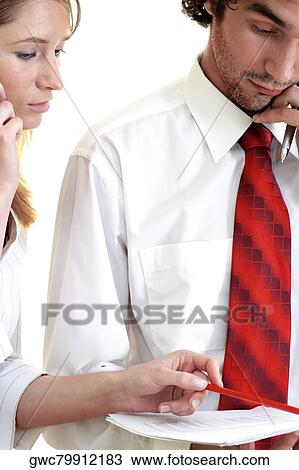 Businessman and a businesswoman looking at a document View Large Photo Image Stock Image - Businessman and a businesswoman looking at a document. Fotosearch
