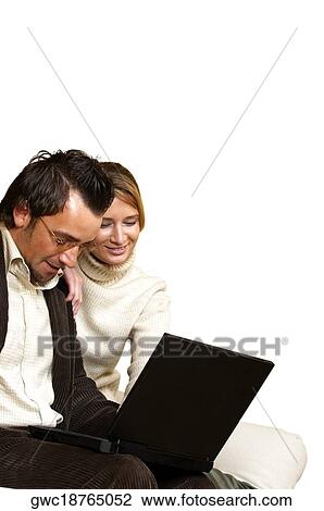 Businessman and a businesswoman sitting in front of a laptop View Large Photo Image Stock Image - Businessman and a businesswoman sitting in front of a laptop. Fotosearch