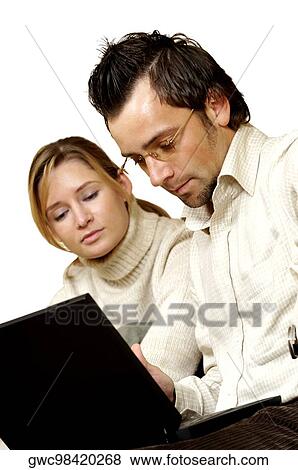 Stock Photo - Businessman and a businesswoman sitting in front of a laptop. Fotosearch