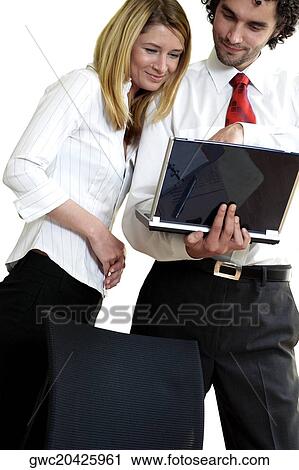 Stock Image - Businessman and a businesswoman using a laptop. Fotosearch