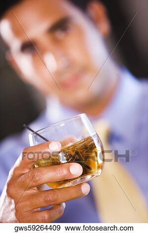 Businessman holding a glass of wine View Large Photo Image Stock Photo - Businessman holding a glass of wine. Fotosearch