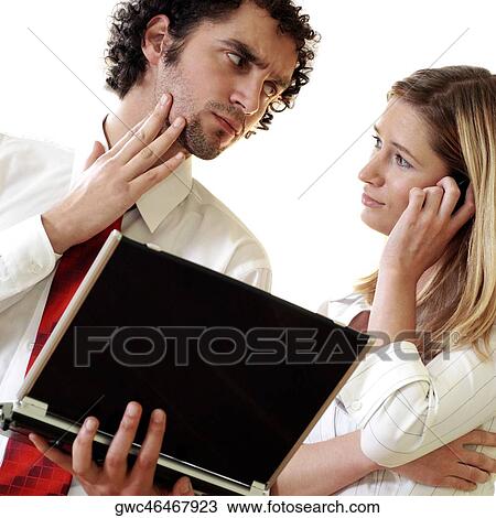 Businessman holding a laptop and a businesswoman talking on a mobile phone View Large Photo Image Stock Image - Businessman holding a laptop and a businesswoman talking on a mobile phone. Fotosearch