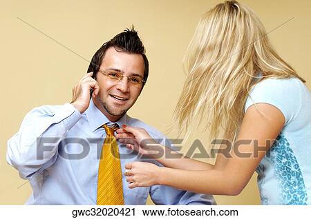 Stock Image - Businesswoman adjusting a businessman's tie. Fotosearch