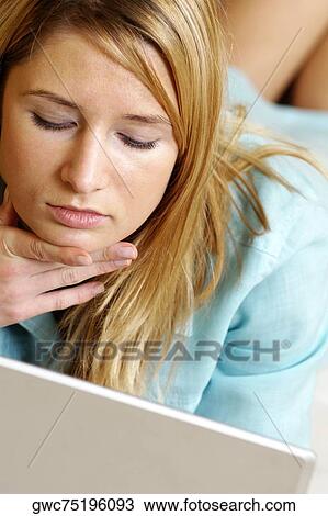 Businesswoman lying in front of a laptop View Large Photo Image Stock Image - Businesswoman lying in front of a laptop. Fotosearch