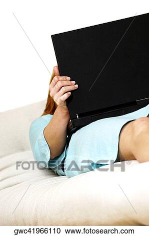Businesswoman lying on a couch with a laptop View Large Photo Image Stock Image - Businesswoman lying on a couch with a laptop. Fotosearch