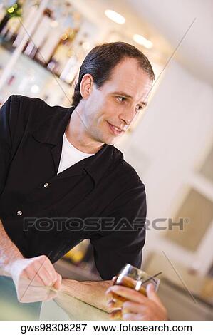 Stock Photo - Close-up of a bartender at a bar counter. Fotosearch