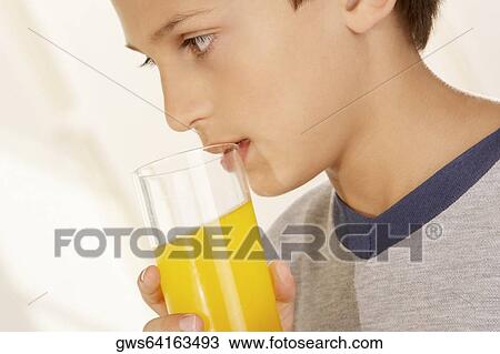 Close-up of a boy holding a glass of orange juice View Large Photo Image Stock Image - Close-up of a boy holding a glass of orange juice. Fotosearch