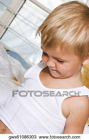 Close-up of a boy looking down and smiling View Large Photo Image Stock Image - Close-up of a boy looking down and smiling. Fotosearch