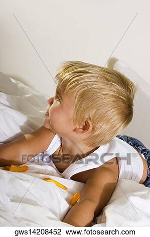 Close-up of a boy lying on the bed View Large Photo Image Stock Image - Close-up of a boy lying on the bed. Fotosearch