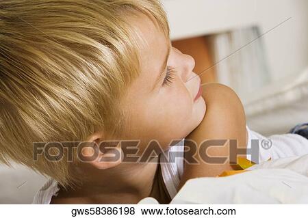 Close-up of a boy lying on the bed View Large Photo Image Stock Photo - Close-up of a boy lying on the bed. Fotosearch