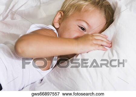 Close-up of a boy lying on the bed View Large Photo Image Stock Photo - Close-up of a boy lying on the bed. Fotosearch
