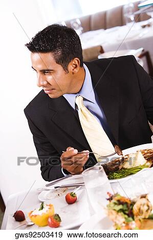 Close-up of a businessman eating View Large Photo Image Stock Photo - Close-up of a businessman eating. Fotosearch