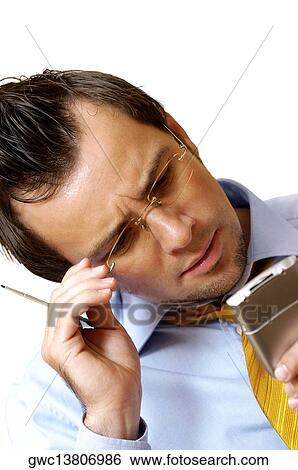 Stock Photograph - Close-up of a businessman operating a personal data assistant. Fotosearch