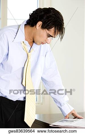 Close-up of a businessman reading a newspaper View Large Photo Image Picture - Close-up of a businessman reading a newspaper. Fotosearch