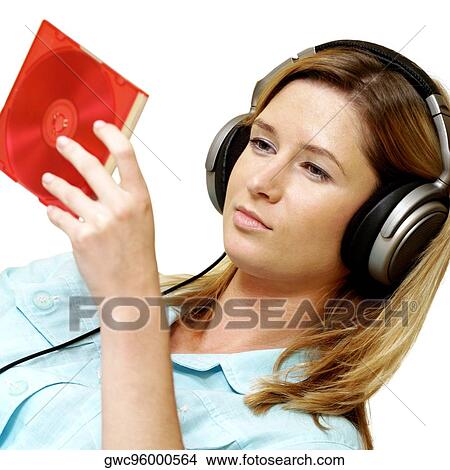 Picture - Close-up of a businesswoman wearing headphones looking at a CD case. Fotosearch
