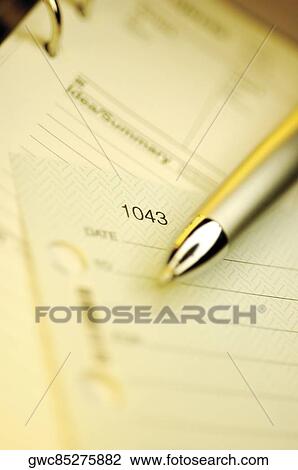 Stock Image - Close-up of a check and a pen on a personal organizer. Fotosearch