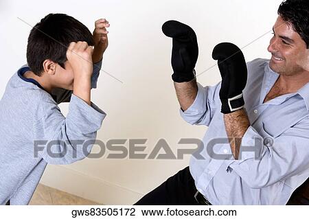 Close-up of a father and his son boxing View Large Photo Image Stock Image - Close-up of a father and his son boxing. Fotosearch