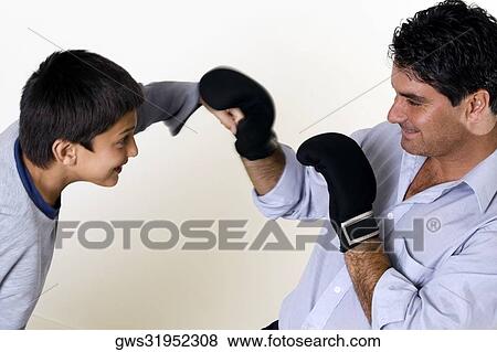 Close-up of a father and his son boxing View Large Photo Image Stock Photo - Close-up of a father and his son boxing. Fotosearch