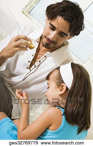 Close-up of a father eating a sandwich with his daughter View Large Photo Image Stock Photo - Close-up of a father eating a sandwich with his daughter. Fotosearch
