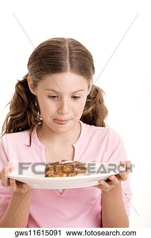 Close-up of a girl holding a donut in a plate licking her lips View Large Photo Image Stock Image - Close-up of a girl holding a donut in a plate licking her lips. Fotosearch