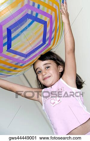 Close-up of a girl holding a large inflatable ball over her head View Large Photo Image Stock Image - Close-up of a girl holding a large inflatable ball over her head. Fotosearch