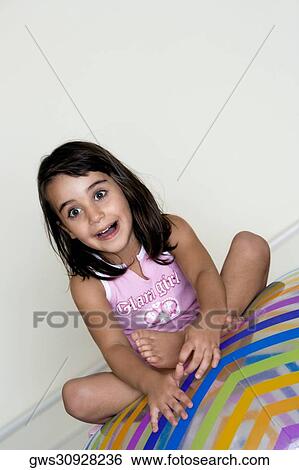 Close-up of a girl sitting on a large inflatable ball View Large Photo Image Stock Photograph - Close-up of a girl sitting on a large inflatable ball. Fotosearch