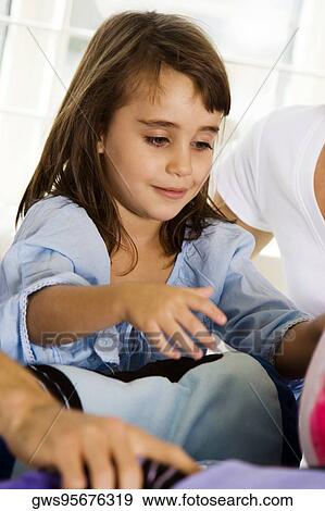 Close-up of a girl sitting with her parents View Large Photo Image Stock Photo - Close-up of a girl sitting with her parents. Fotosearch