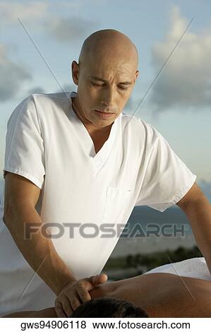 Close-up of a massage therapist giving a young man a back massage View Large Photo Image Stock Photo - Close-up of a massage therapist giving a young man a back massage. Fotosearch