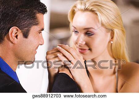 Stock Image - Close-up of a mid adult man and a young woman holding hands. Fotosearch
