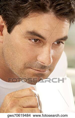 Picture - Close-up of a mid adult man drinking a cup of coffee. Fotosearch