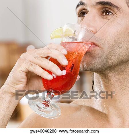 Close-up of a mid adult man drinking a cocktail View Large Photo Image Stock Photo - Close-up of a mid adult man drinking a cocktail. Fotosearch