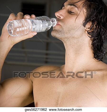 Close-up of a mid adult man drinking water from a bottle View Large Photo Image Stock Image - Close-up of a mid adult man drinking water from a bottle. Fotosearch