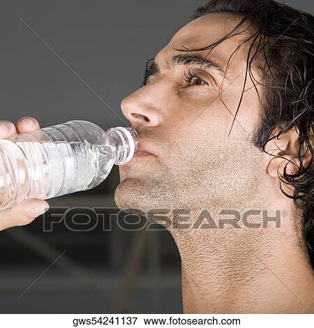 Close-up of a mid adult man drinking water View Large Photo Image Stock Photo - Close-up of a mid adult man drinking water. Fotosearch