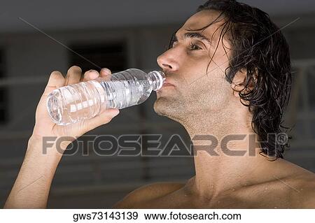 Close-up of a mid adult man drinking water from a bottle View Large Photo Image Stock Photo - Close-up of a mid adult man drinking water from a bottle. Fotosearch